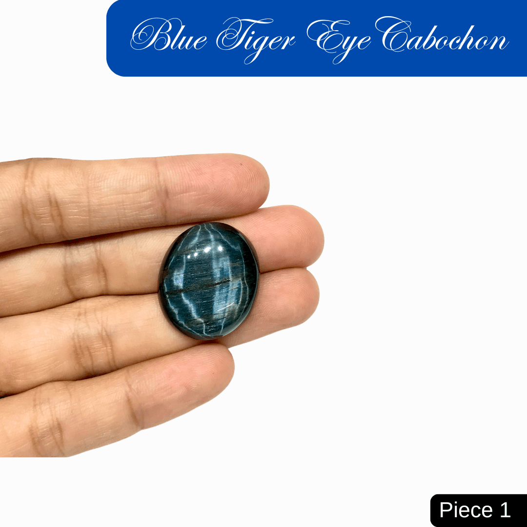 Close-up of a blue tiger eye cabochon on hand, showing its silky luster and chatoyant bands. Ideal for insight and protection.