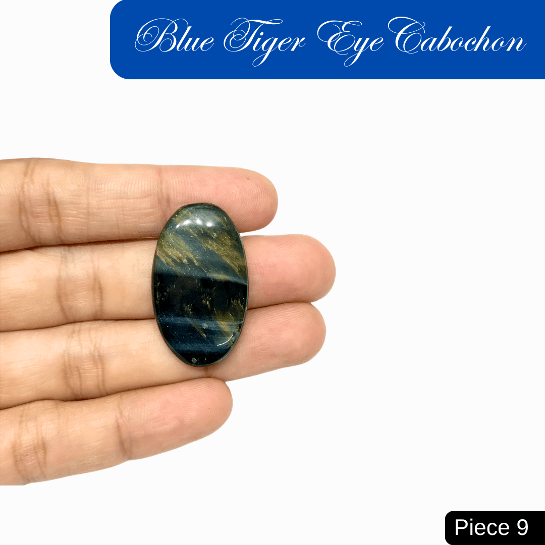 Blue Tiger Eye Cabochon with silky luster and chatoyant bands, known for insight and protection, displayed on a hand. Piece 9.