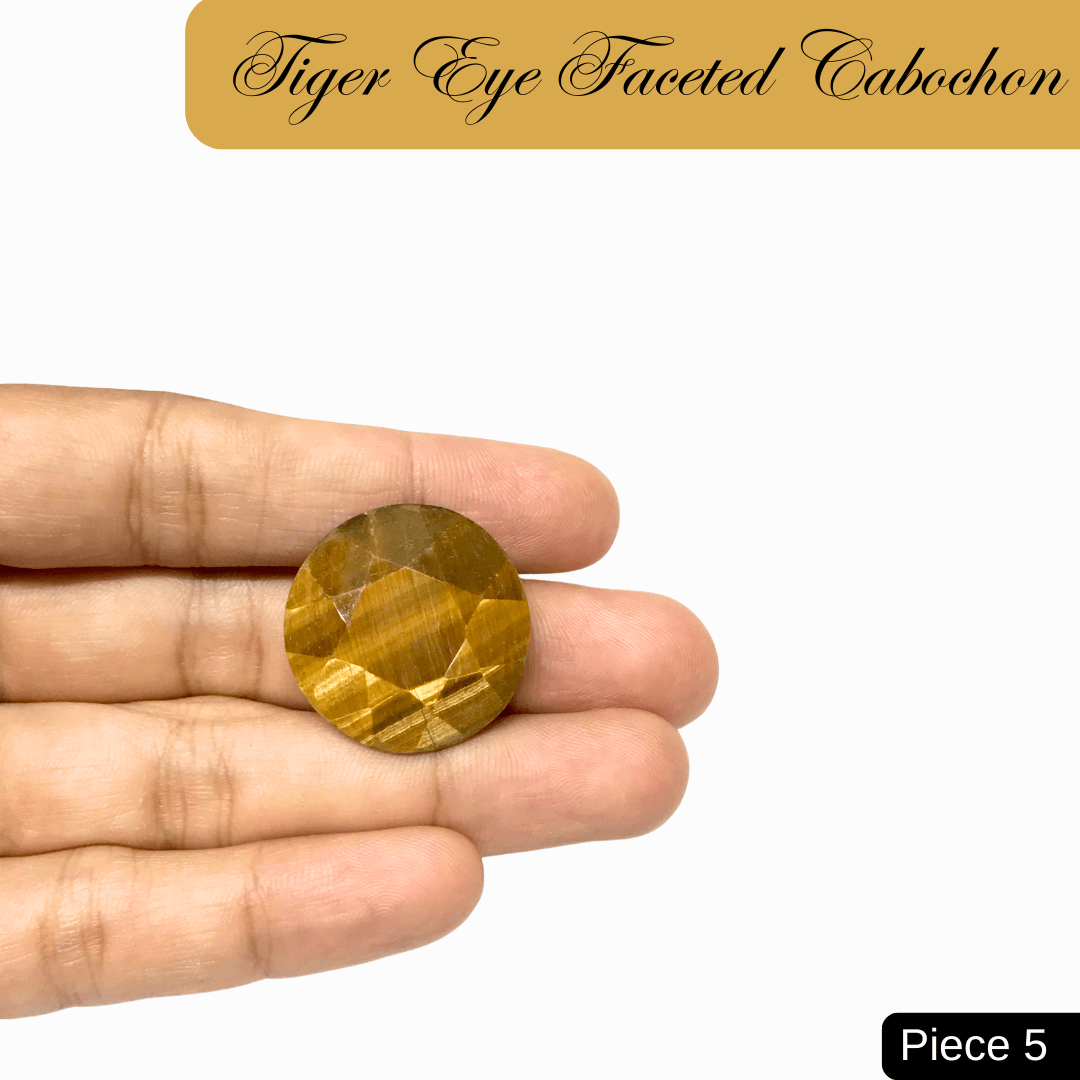 Hand holding a faceted Tiger Eye cabochon, showcasing its golden-brown bands and silky chatoyancy, symbolizing strength and focus.