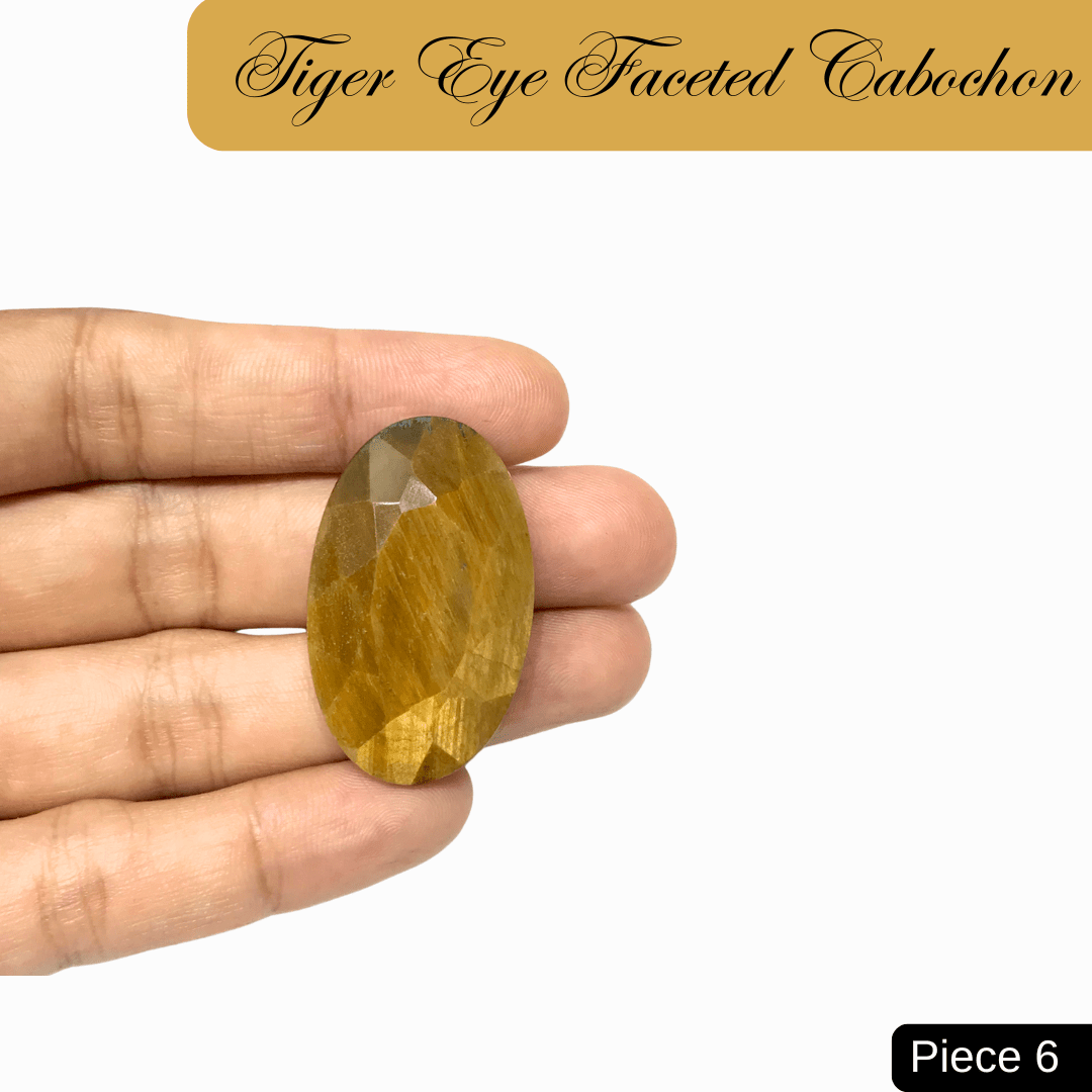 Hand holding faceted Tiger Eye cabochon, showcasing golden-brown bands and silky chatoyancy, symbolizing clarity and confidence.