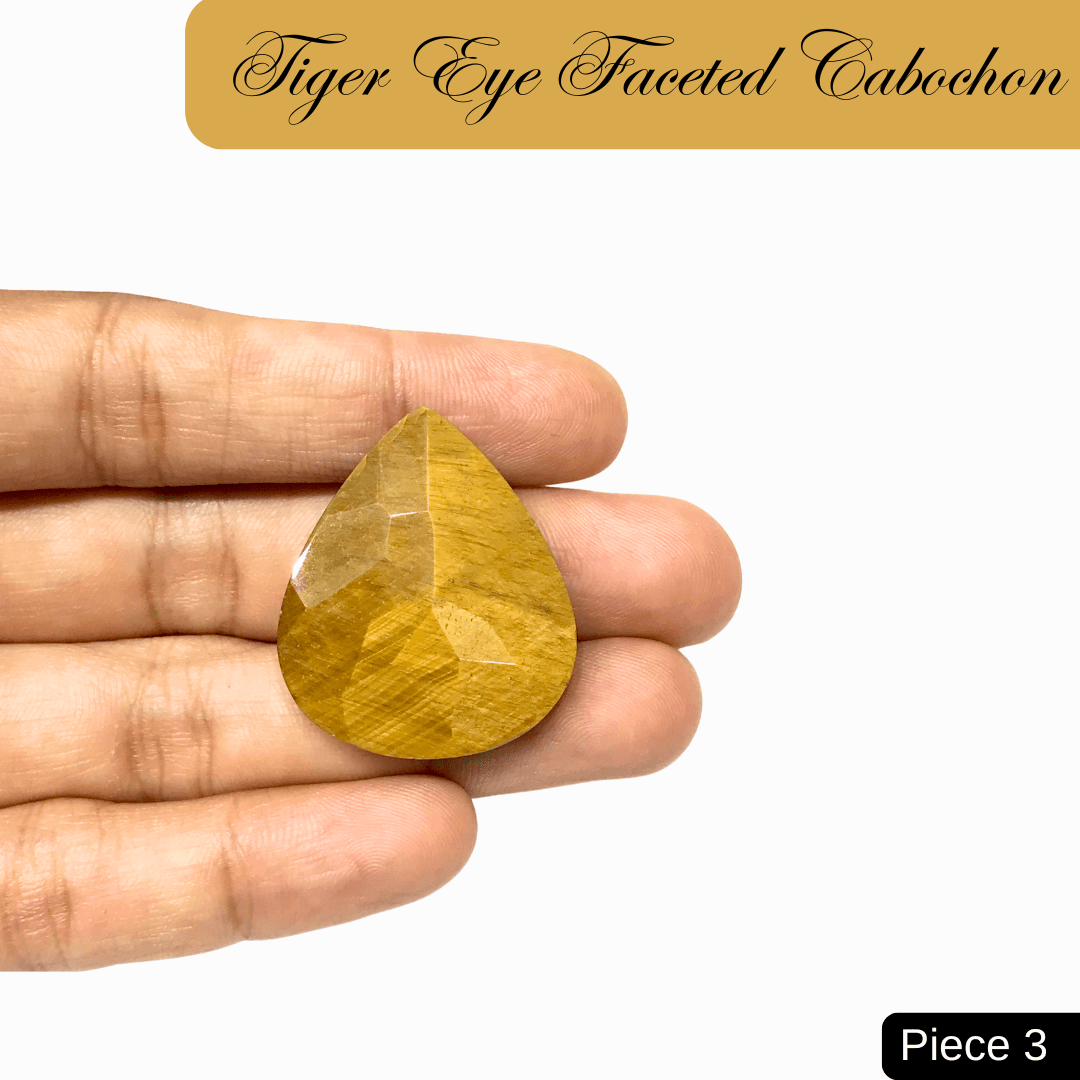 Hand holding a faceted Tiger Eye cabochon gemstone, showcasing its chatoyancy and golden-brown bands, known for clarity and confidence.