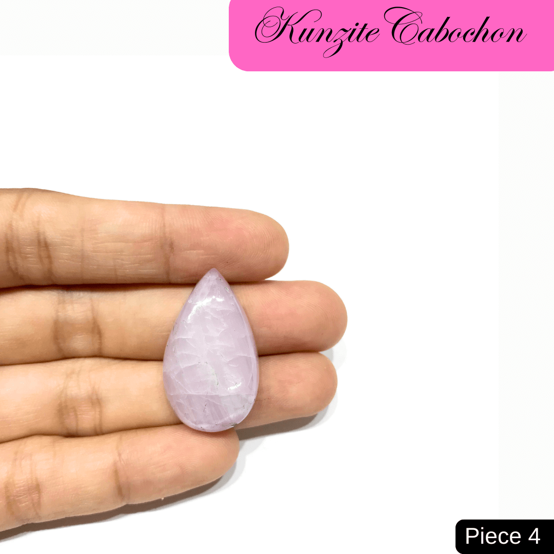 Teardrop Kunzite cabochon in soft pink hues held in hand, showcasing its radiant and delicate appearance.