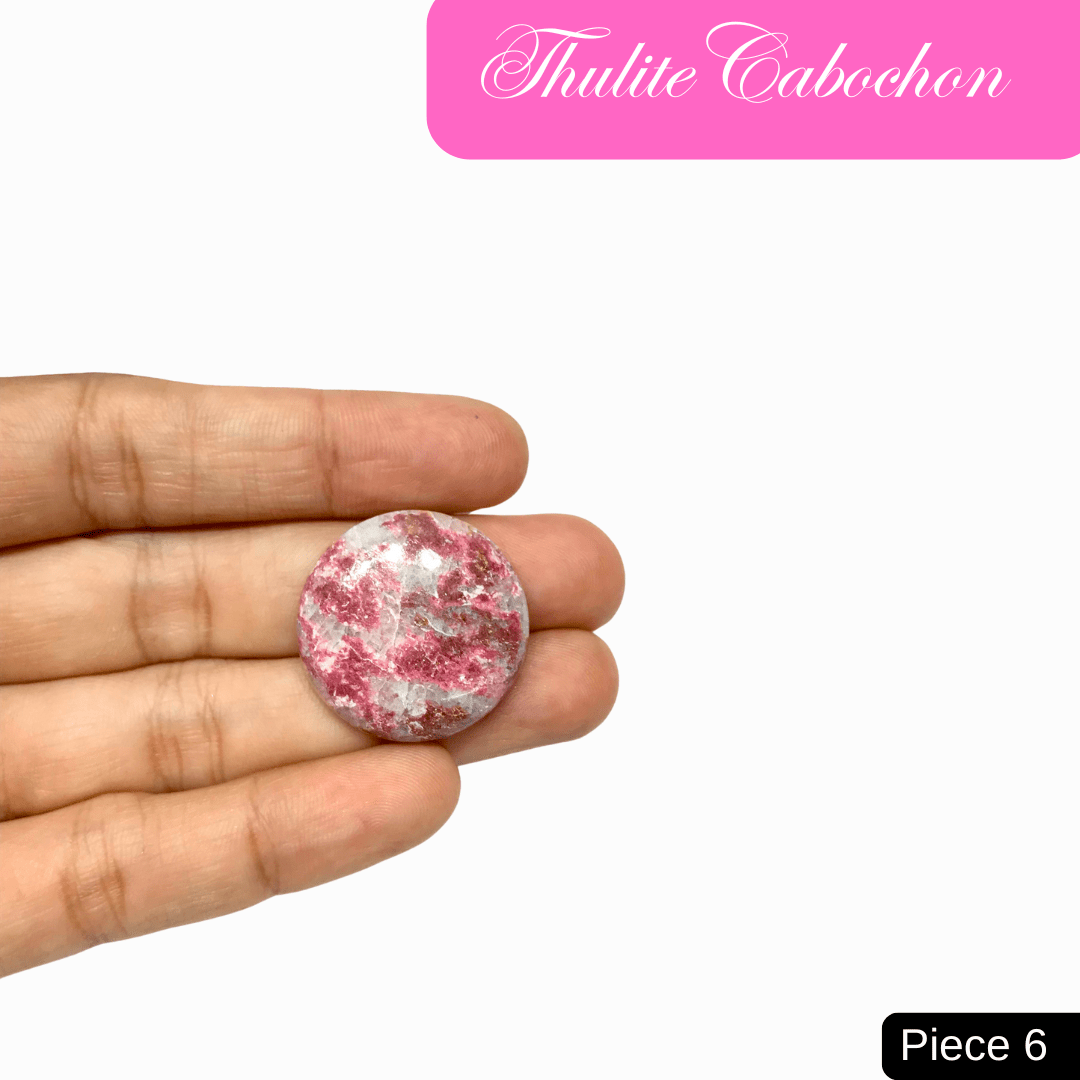 "Thulite Cabochon in hand, showcasing pink mineral hues, ideal for promoting love and emotional healing. Piece 6."