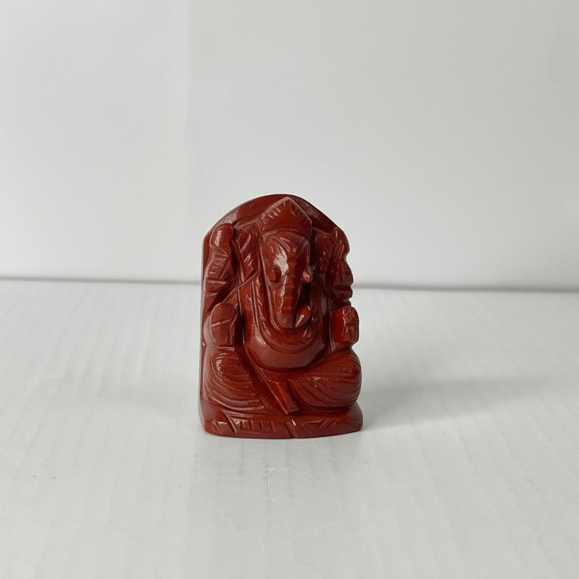 Brown stone sculpture of a deity on a white background