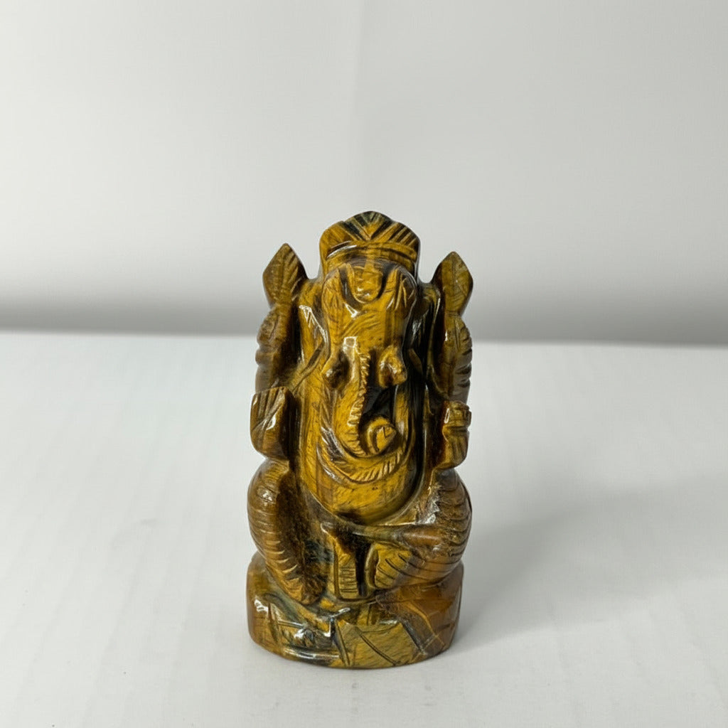 Brown stone statue of a seated figure on a white background