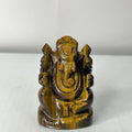 Tiger's eye stone sculpture of a deity on a white background