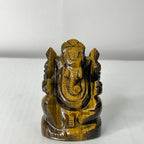 Tiger's eye stone sculpture of a deity on a white background