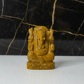 Brown stone sculpture of a deity on a white background
 Aeora rocks yellow jasper ganesha