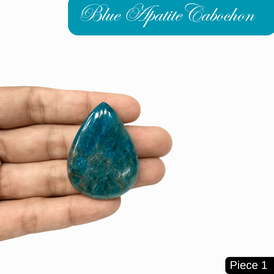 Hand holding a teardrop-shaped blue apatite cabochon gemstone, showcasing its vibrant ocean blue color and translucent quality.