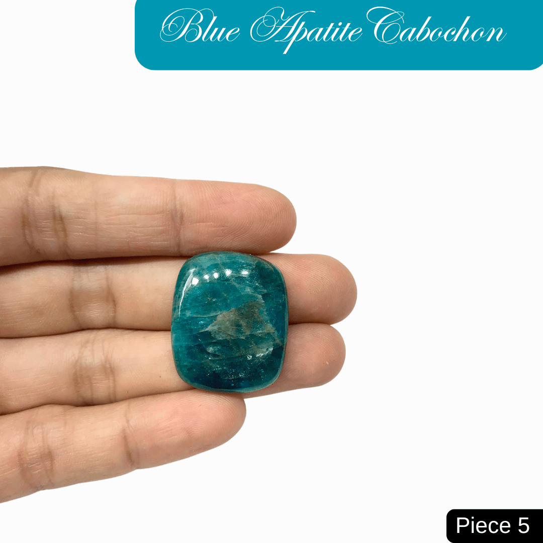Hand holding a vibrant blue apatite cabochon gemstone showcasing its deep ocean blue to bright turquoise hues.