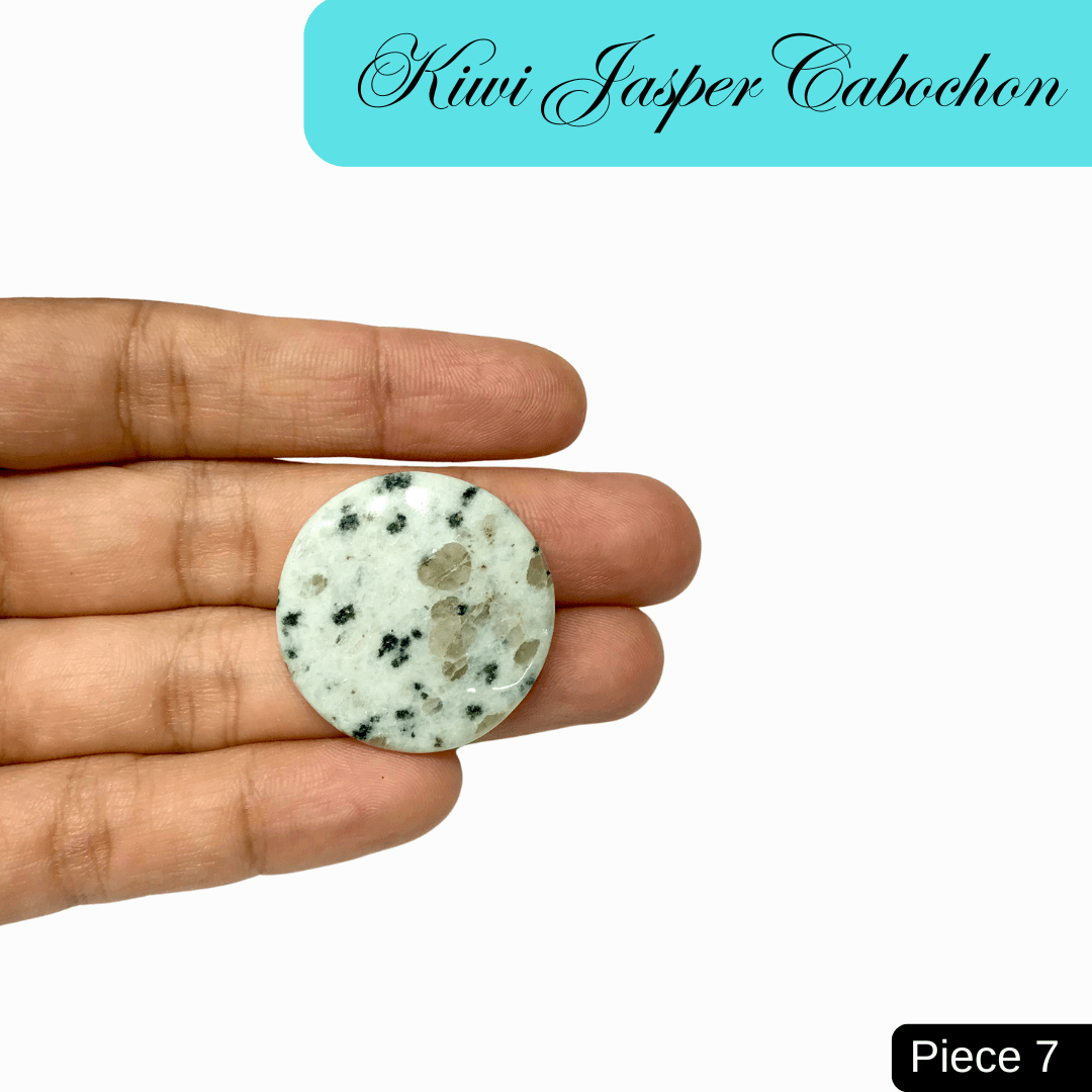 Hand holding Kiwi Jasper cabochon with green, black, and cream patterns for tranquility and emotional strength.