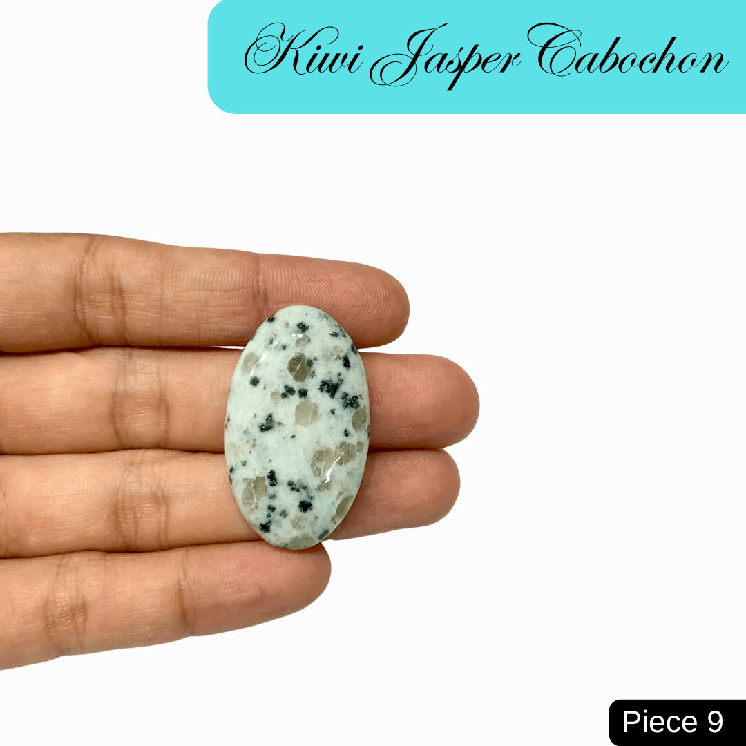 Hand holding a Kiwi Jasper cabochon with soft green, black, and cream speckles, ideal for tranquility and emotional balance.