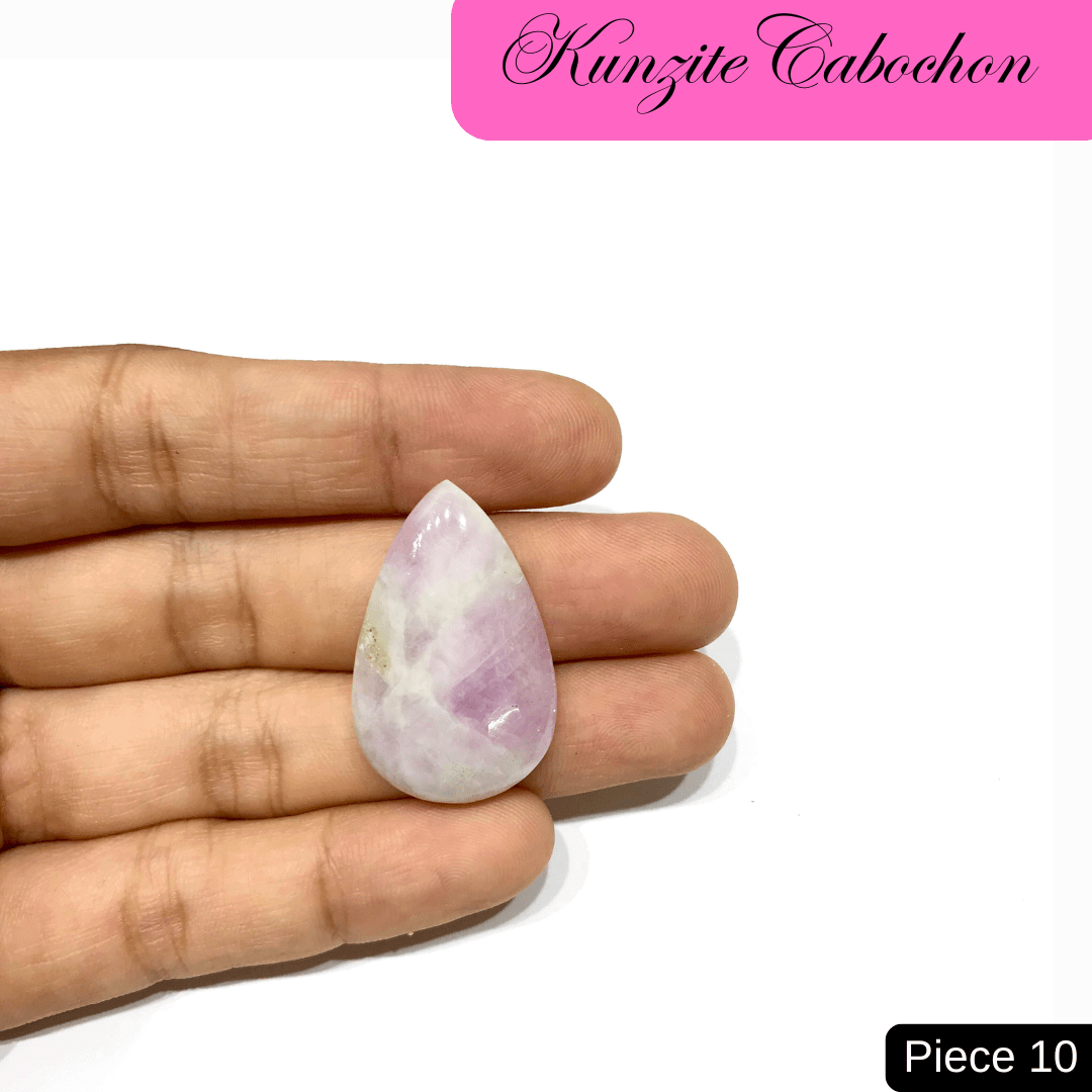 Hand holding a teardrop-shaped Kunzite Cabochon with soft pink hues, known for love and emotional healing properties. Piece 10