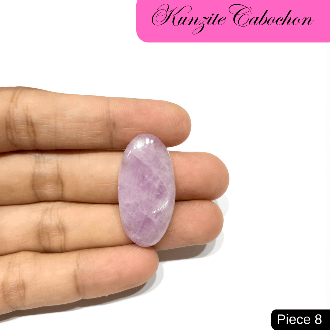 Hand holding a soft pink Kunzite cabochon, renowned for its high-vibrational energy and associations with love and emotional healing.