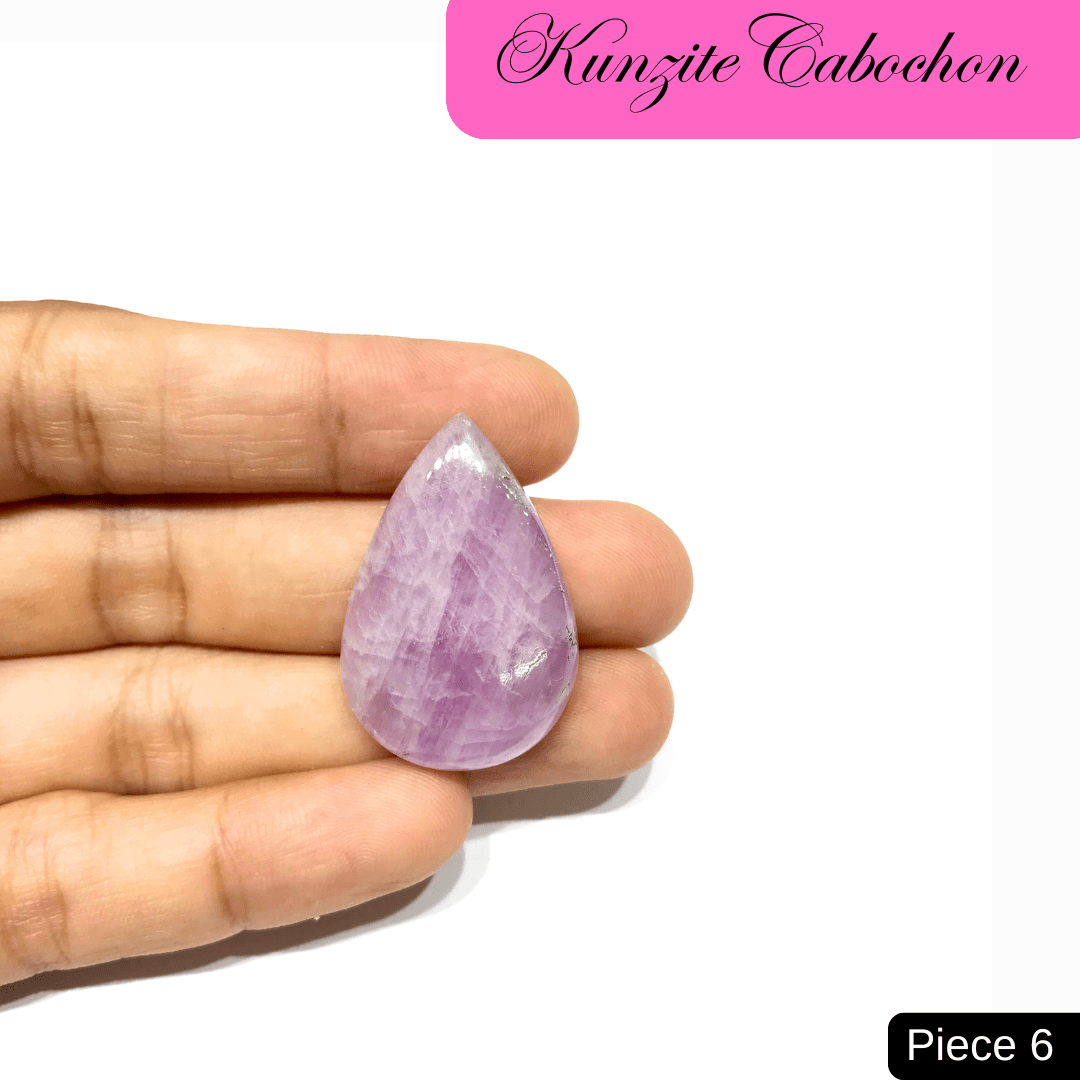 Close-up of a soft pink Kunzite cabochon gemstone held in hand, showcasing delicate hues and high-vibrational energy qualities.