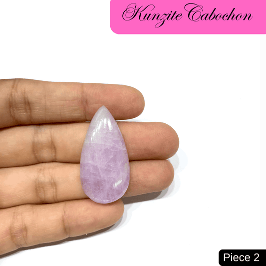 Teardrop Kunzite Cabochon in soft lilac hue held in hand, known for emotional healing and spiritual awakening.