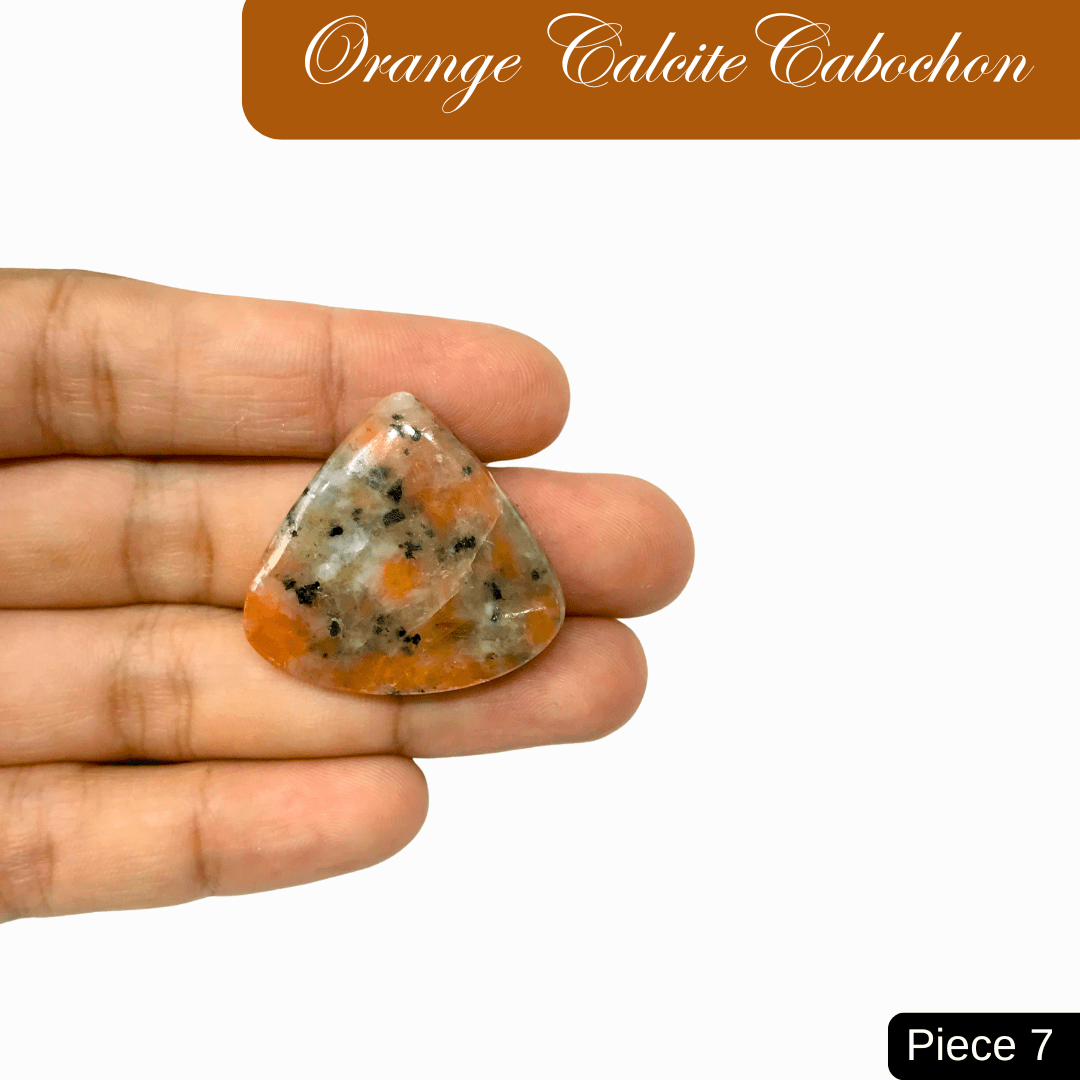 Hand holding vibrant triangular Orange Calcite cabochon, symbolizing creativity and energy. Piece 7 offers sunny hues and healing properties.