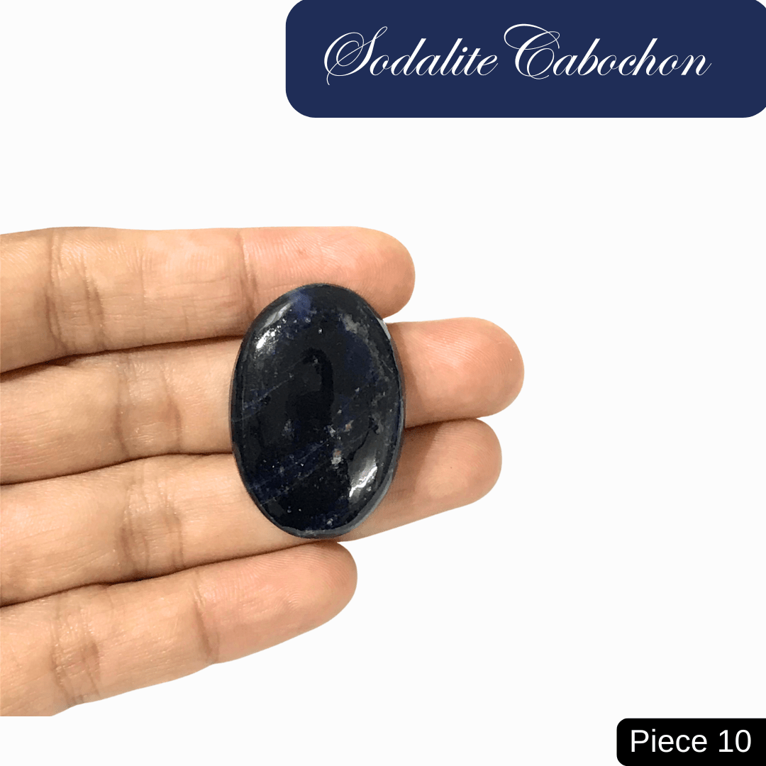 Hand holding a sodalite cabochon with deep blue tones and white calcite, promoting intuition, clarity, and genuine communication.