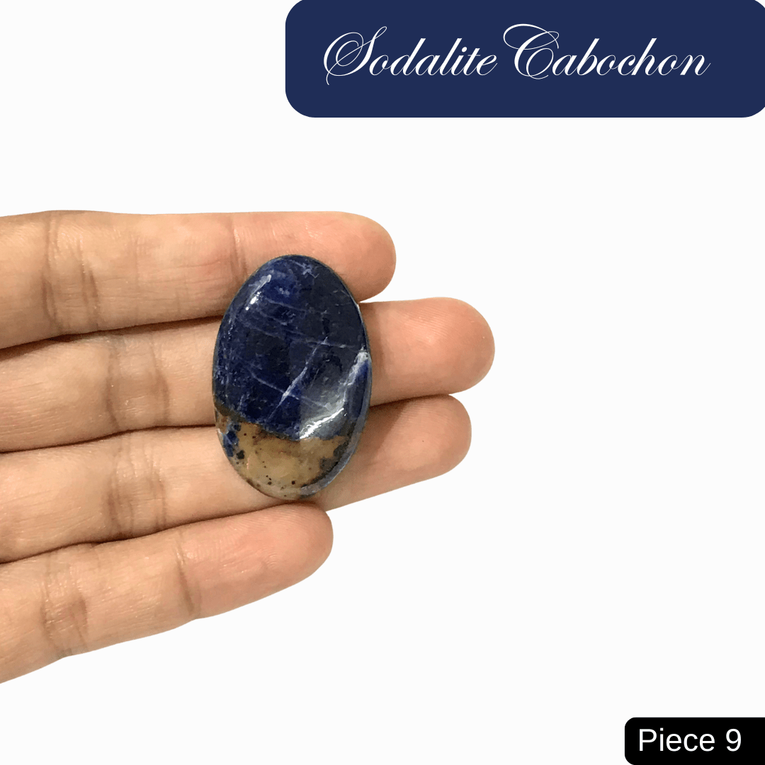 Hand holding an oval sodalite cabochon with deep blue and white calcite veins, symbolizing truth and intuition.