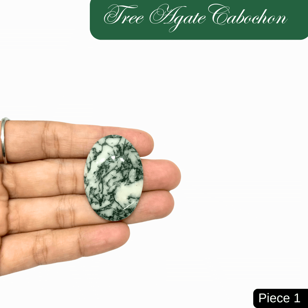 Hand holding a Tree Agate cabochon with green and white marbled patterns, symbolizing inner peace and connection to nature.