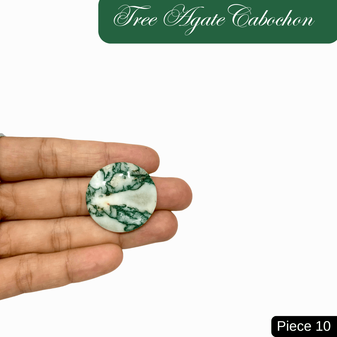 Hand holding a round Tree Agate cabochon with green and white marbled patterns, symbolizing inner peace and connection to nature.